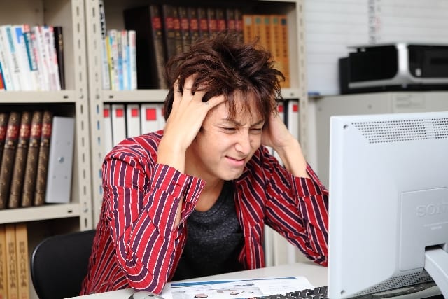 Photoshopの膨大な機能を目にして頭をかいて悩んでいる男性の画像