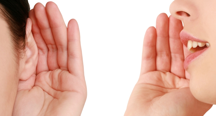 左側の人が耳に手を当てて聞き取り、右側の人が口に手を当てて声を発している画像
