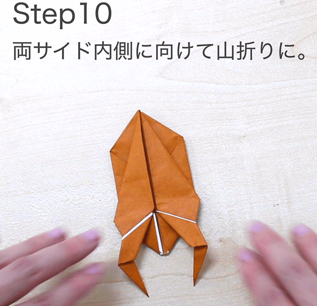 折り紙クワガタの折り方のSTEP10の画像。両サイドを内側に向けて山折りにします